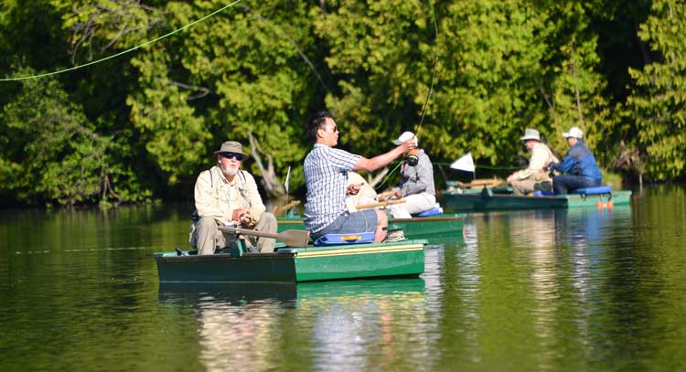 Group of men in multiple boats fishing