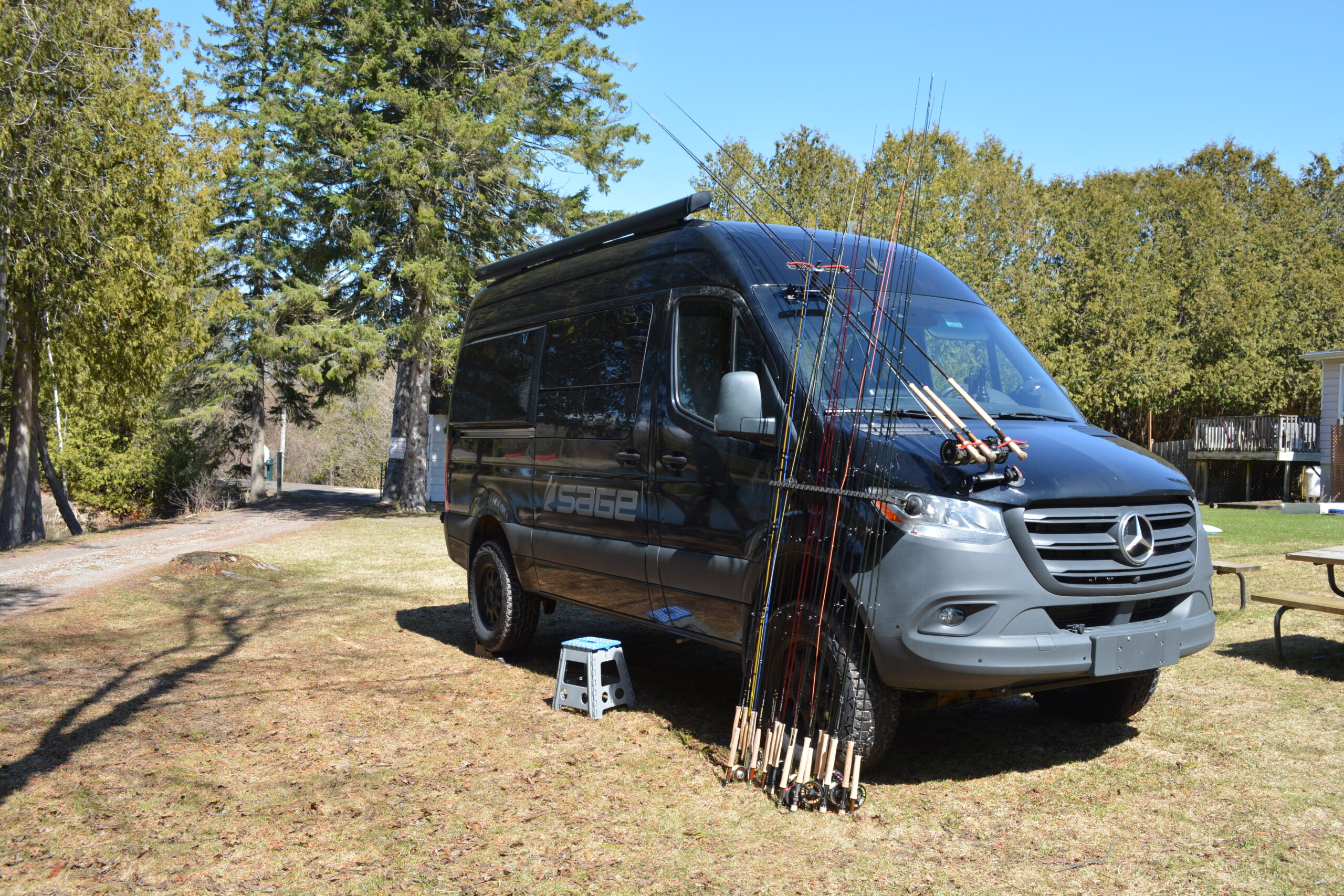 DSC_0757 A group photo of four smiling men standing together inside the clubhouse during a fly-tying instructional event.